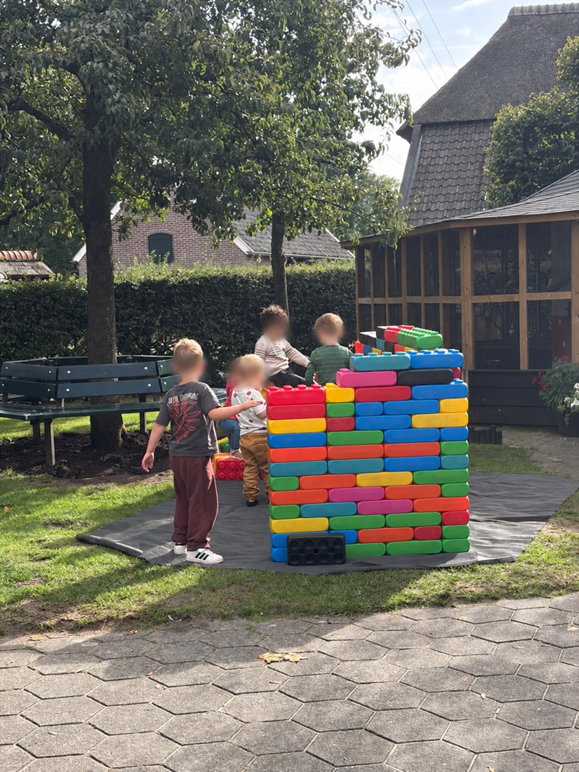 Children playing with large colourful building blocks at the petting farm during the Momentum and Buurtgezinnen afternoon