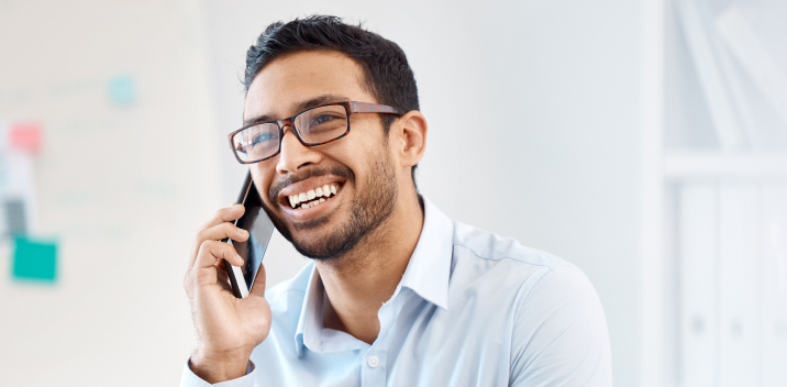 Momentum Telecom customer speaking on a cellphone and smiling while wearing a blue shirt